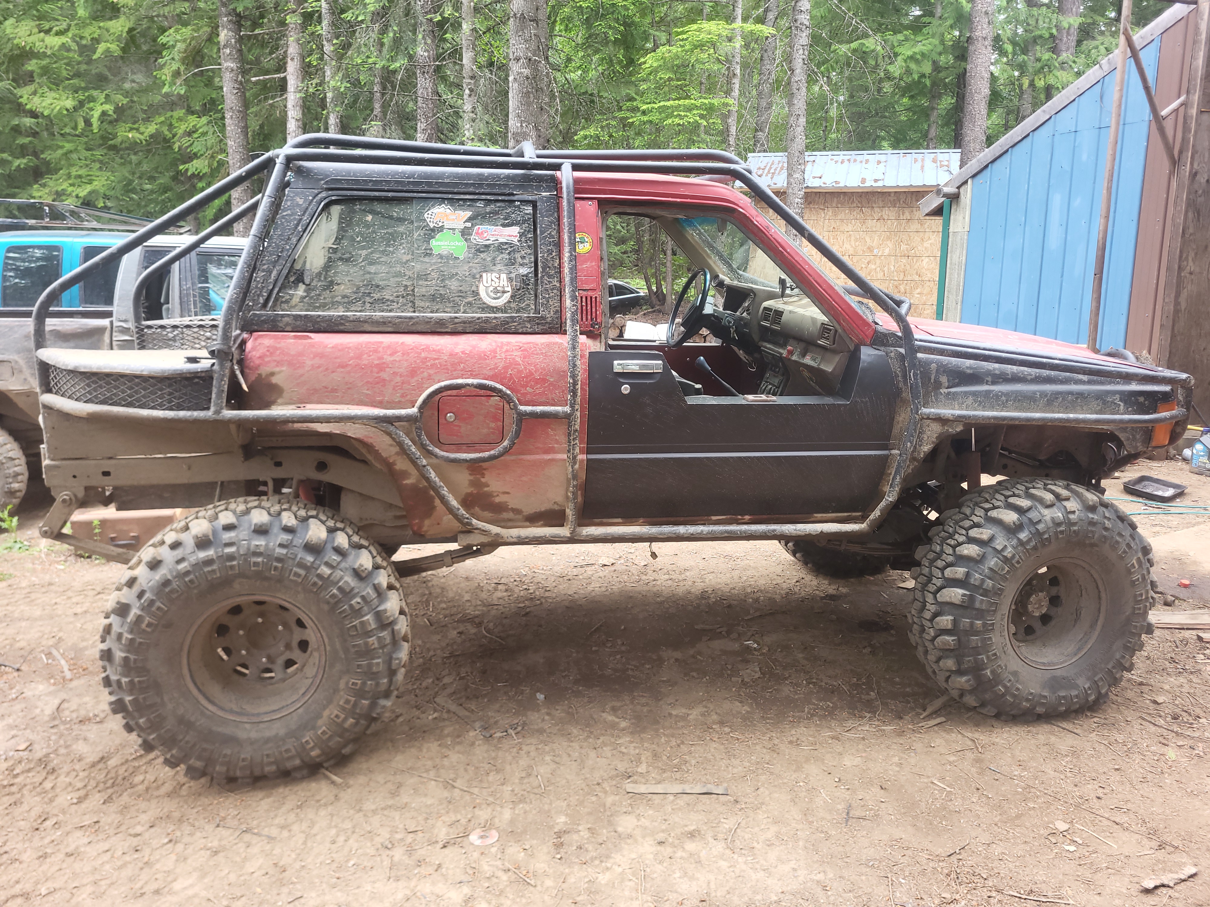 Side profile of bobbed 1985 4Runner with full exo cage and mud-covered tires